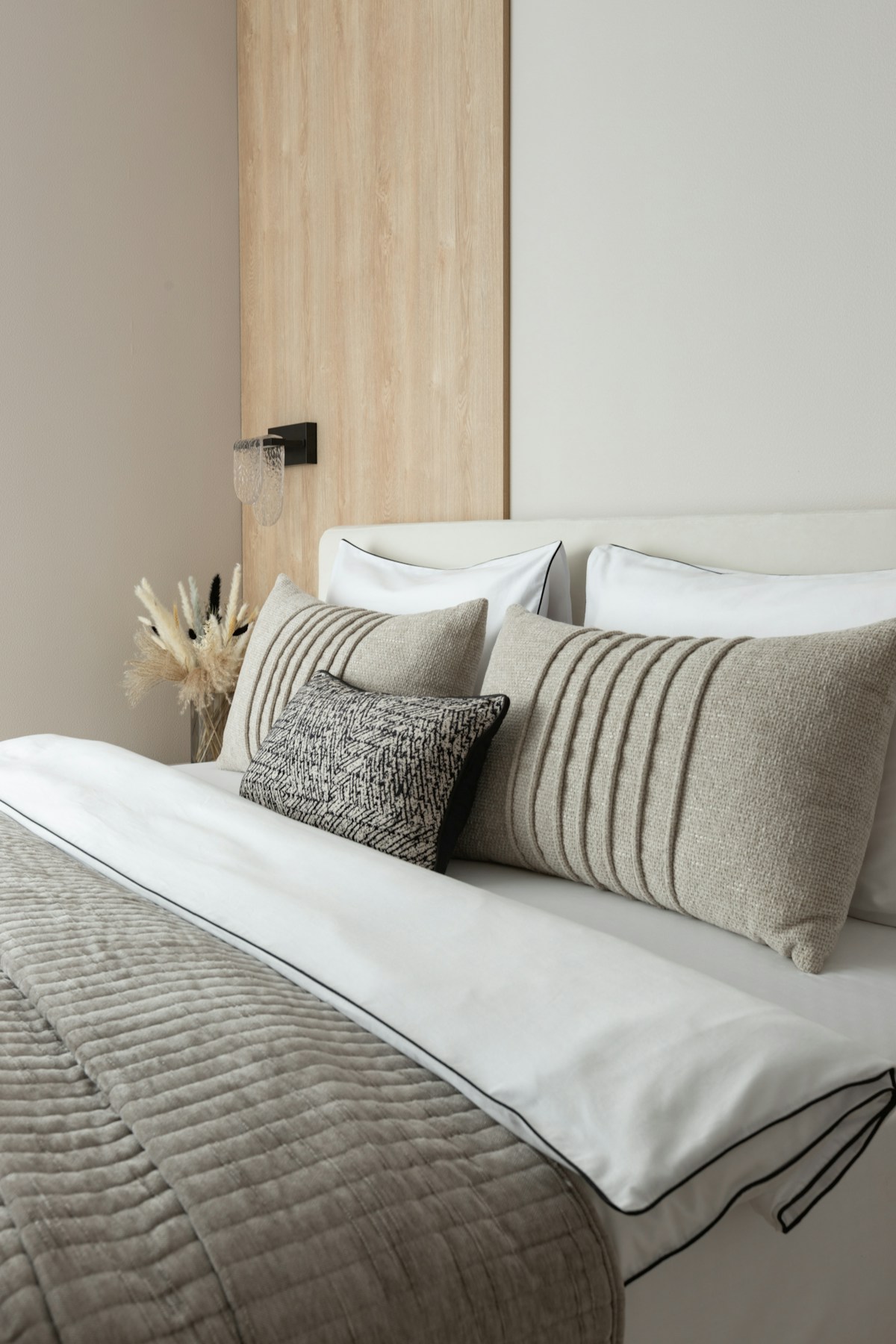 Modern bedroom with neutral-toned pillows and bedding.